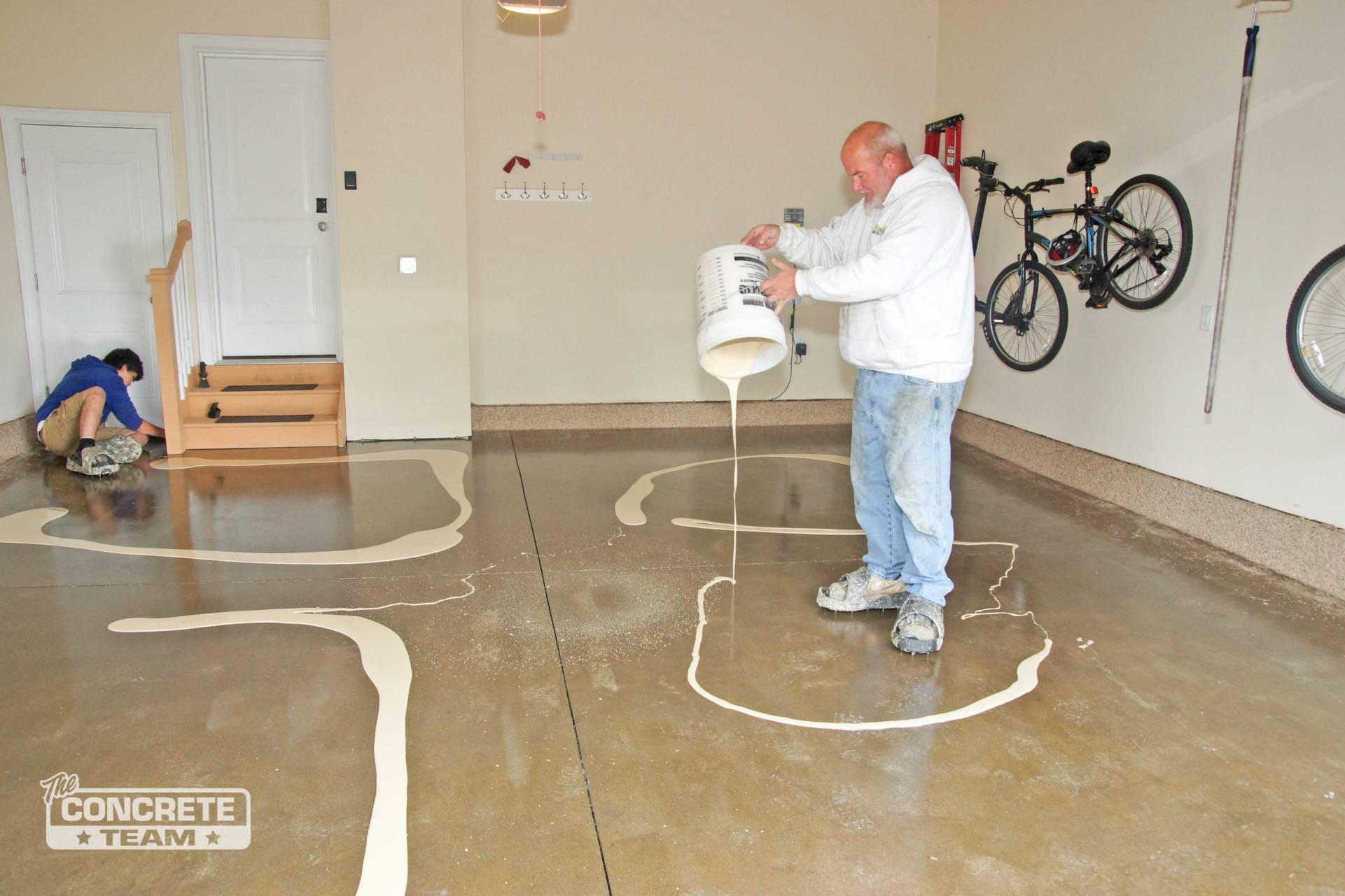 Two men working on a concrete garage floor installation